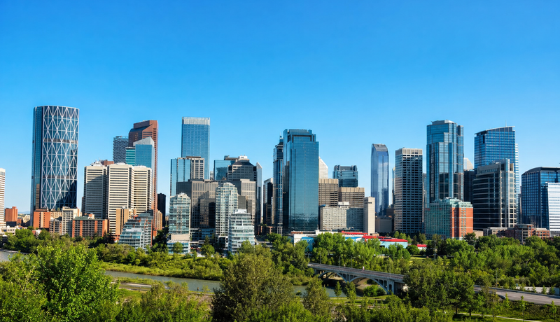 News thumbnail photograph of a modern city skyline viewed over a river valley or broad green foreground.
